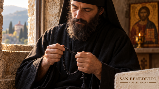 Eastern Christian monk prayerfully holds a black wool komboskini in a monastery; San Benedetto Collections.